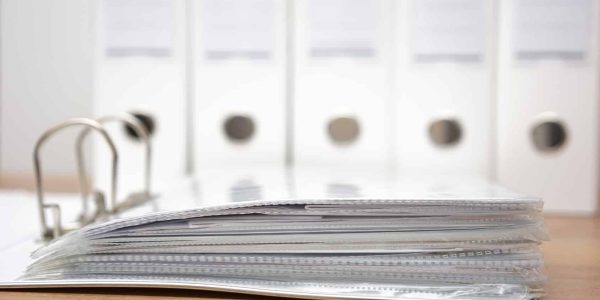 folders with documentation with binders in background
